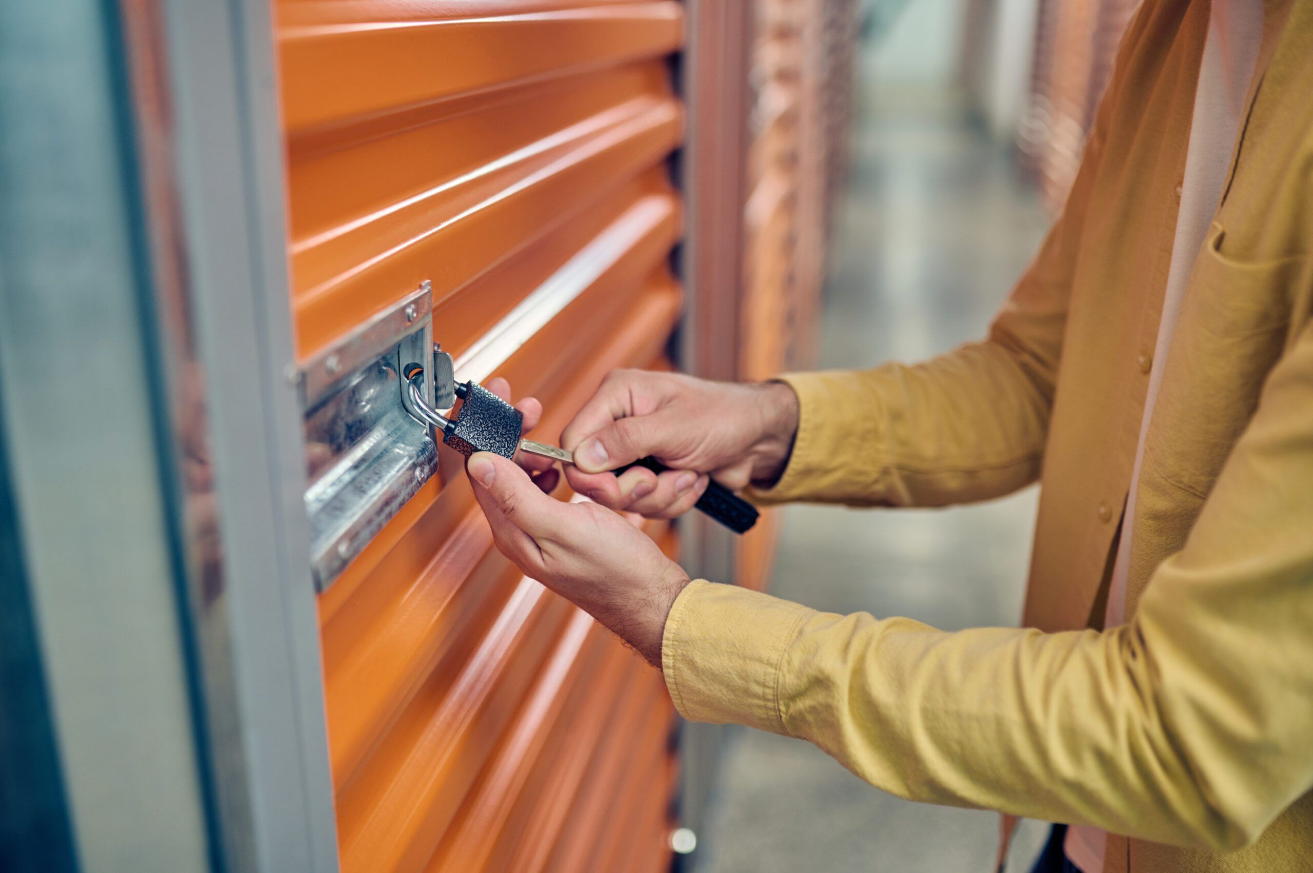 Worker padlocking the door of the storage unit