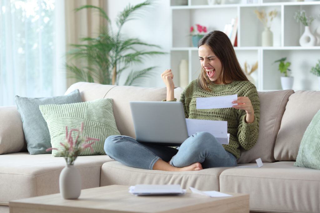Excited woman in green checking bill online